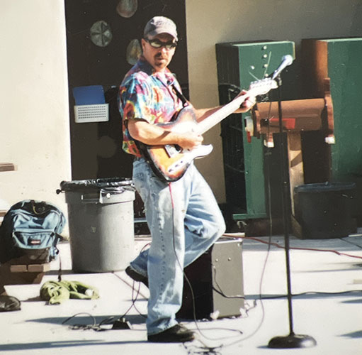 Man in colorful shirt playing electric guitar